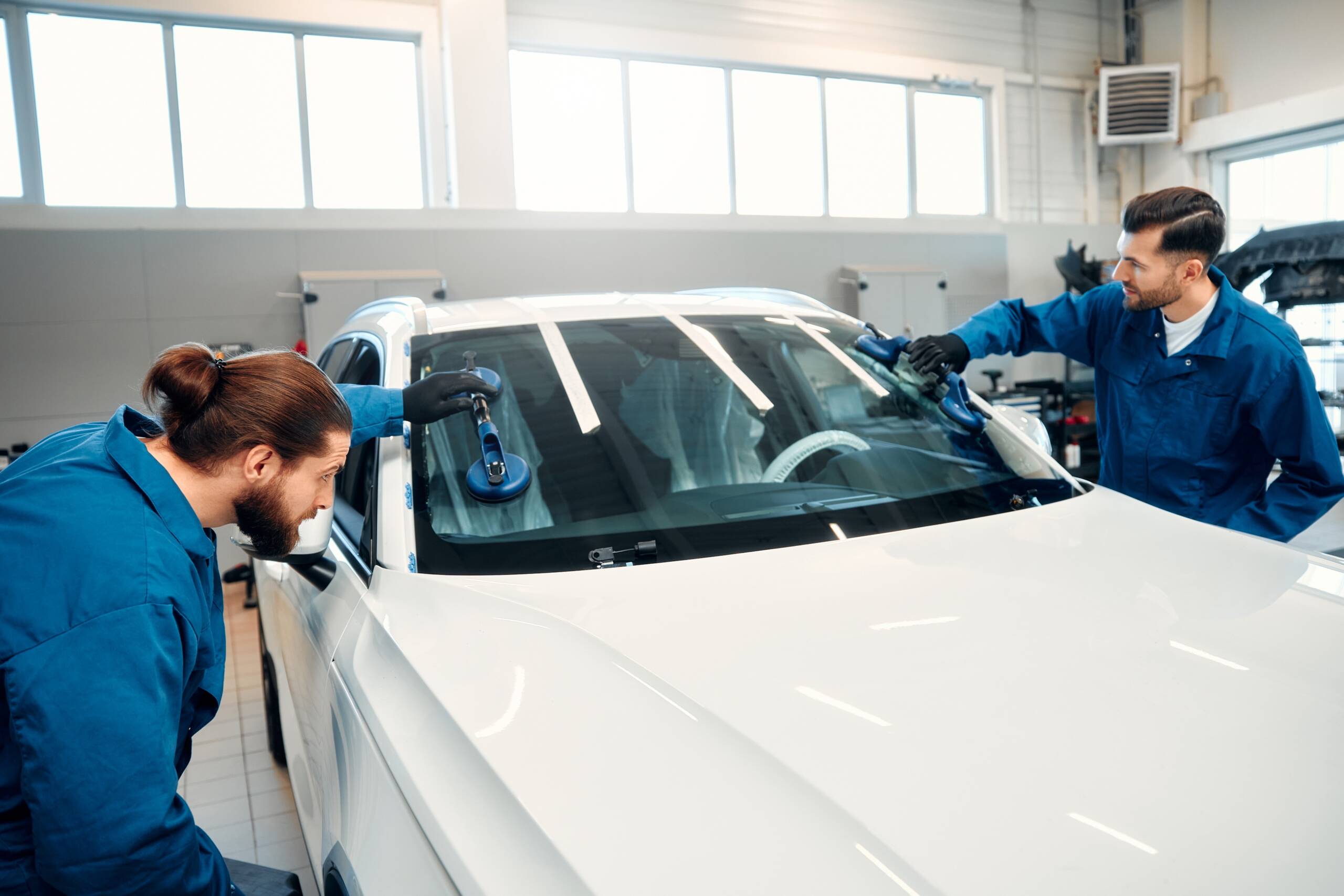 Due tecnici Croce Auto Group che montano un nuovo parabrezza con strumenti a ventosa, prima della calibrazione ADAS.